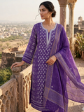 Woman in a purple traditional outfit standing on a balcony with a scenic view.